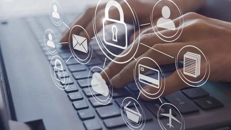 A close-up of hands typing on a keyboard, surrounded by digital security icons like a lock, email, and cloud storage.